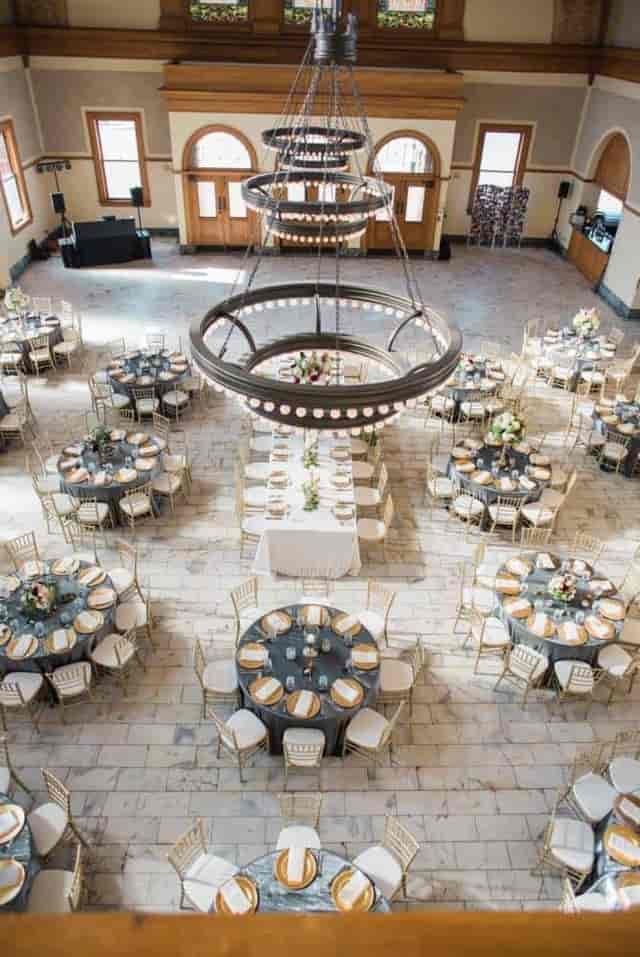 Elegant outdoor event space with gray tables and gold accents at The Ashton Depot.