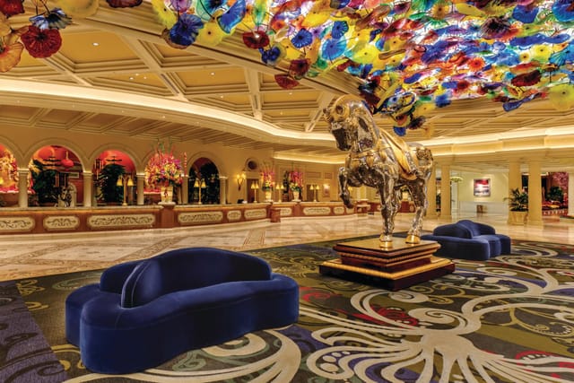 Elegant Bellagio Casino lobby with colorful chandelier and golden horse statue for upscale events.