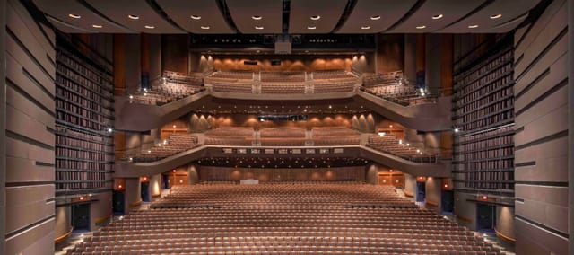 Spacious auditorium in Bass School for conferences and events, featuring tiered seating.