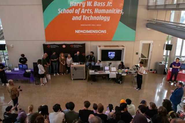 Dynamic event at Bass School of Arts featuring engaged audience and tech booths.