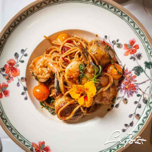 Shrimp pasta garnished with tomatoes at La Forêt for events and catering.