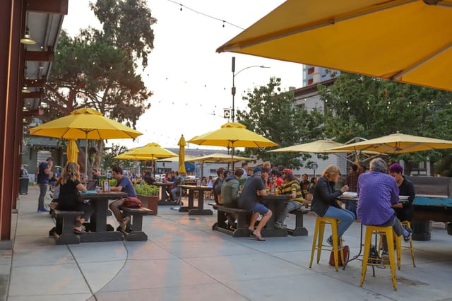 Three Sisters Patio with yellow umbrellas, perfect for casual networking events in San Pedro Square.