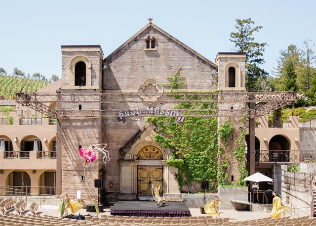 Outdoor event venue at The Mountain Winery with historic stone building and scenic backdrop.