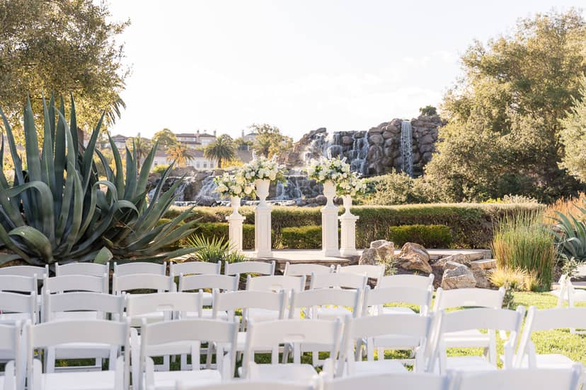 Lakeside wedding ceremony site with floral altar and waterfall backdrop in Silver Creek Valley.