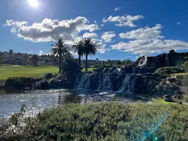 Outdoor venue with waterfall and palm trees, perfect for retreats or corporate events.