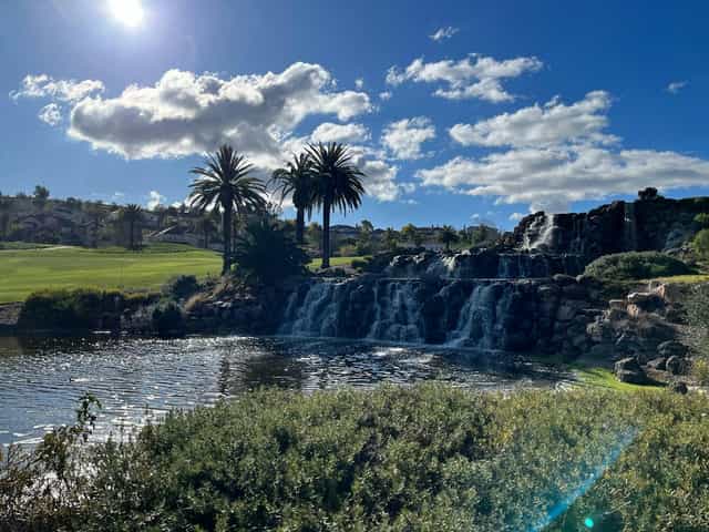 Outdoor venue with waterfall and palm trees, perfect for retreats or corporate events.