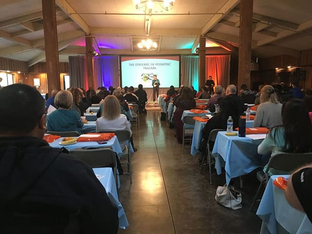 Heritage Hall event setup with blue linens for a professional conference presentation.