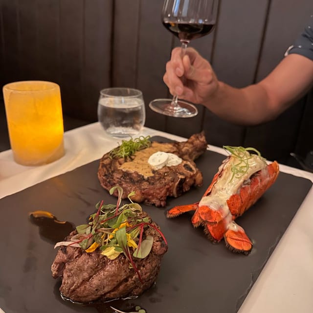 Elegant dining setup at Alexander's Steakhouse with steak and lobster for corporate events.