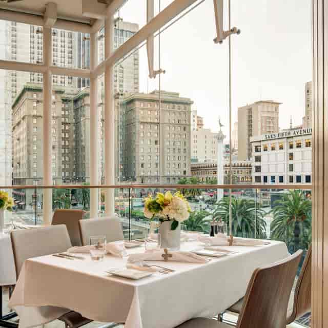 Private dining room with elegant table setup and city view for upscale events.