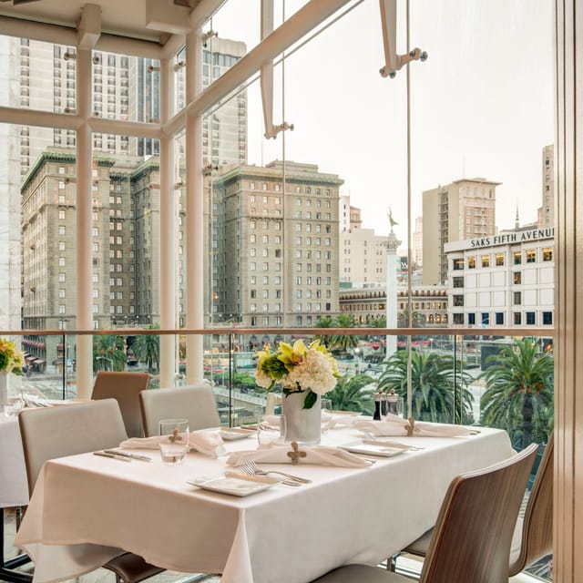 Private dining room with elegant table setup and city view for upscale events.