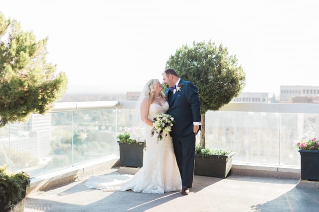 Wedding couple celebrating on rooftop patio with city skyline in Silicon Valley.