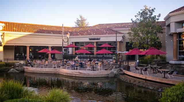 Outdoor event space at The Grille, featuring umbrellas and tranquil water for gatherings.