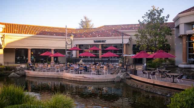 Outdoor event space at The Grille, featuring umbrellas and tranquil water for gatherings.