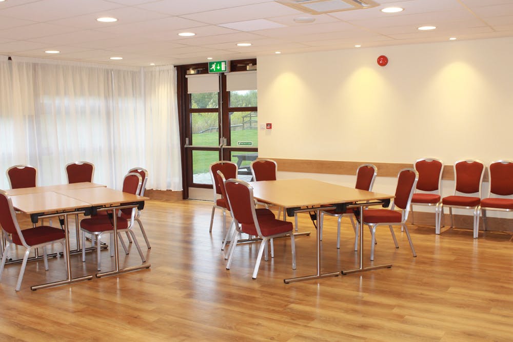 Versatile meeting space at The Grange, featuring wooden flooring and natural light for workshops.