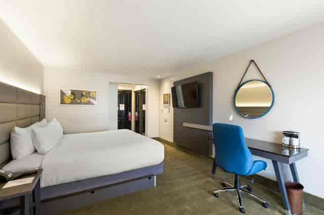 Modern hotel room with comfortable bed at Crowne Plaza San Jose for meetings and events.