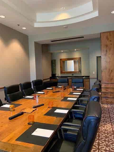 Executive Boardroom at Hotel Valencia: large wooden table, ergonomic chairs, business meeting.
