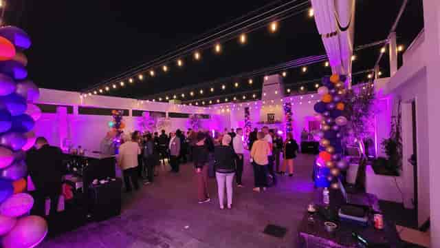 Vibrant rooftop event space in Blanco Urban Venue with purple lighting and festive decor.