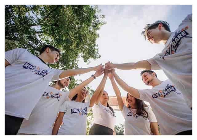 Team huddle in Napredak Hall outdoor area, showcasing unity at an event.