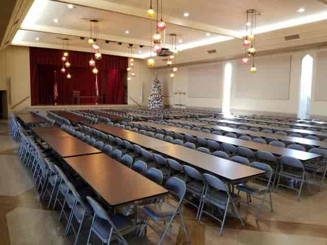 Spacious Napredak Hall with customizable stage for events and colorful pendant lights.