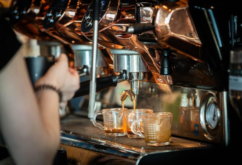 Barista extracting espresso at Coffee bar in Field Arts & Events Hall for event services.