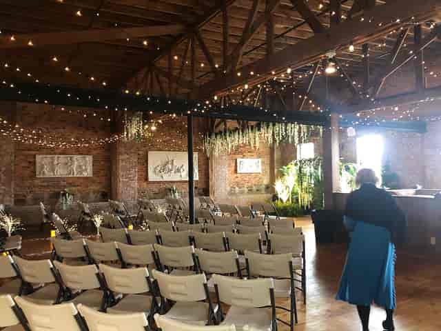 Elegant event space with exposed brick and greenery, perfect for weddings or receptions.