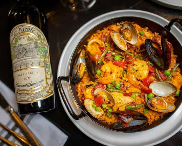 Private dining room at Scott's Seafood with vibrant seafood paella and Napa Valley Cabernet.