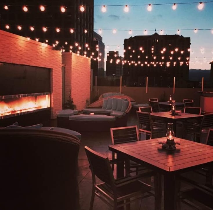 Outdoor patio event space at Scott's Seafood with string lights and city backdrop.