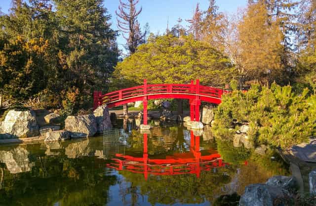 Okayama Room in Kelley Park with red bridge over tranquil water for outdoor events.