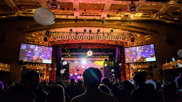 Amusement center event with dynamic lighting, balloons, and confetti celebration.