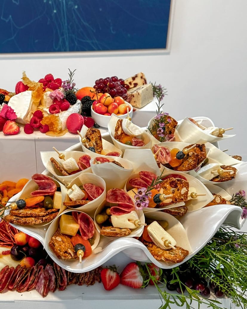 Grazing table charcuterie display with gourmet cheeses and fruits for event receptions.