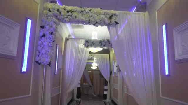 Elegant wedding hallway with floral arch and drapes at Oasis Palace Premium Hall 3.