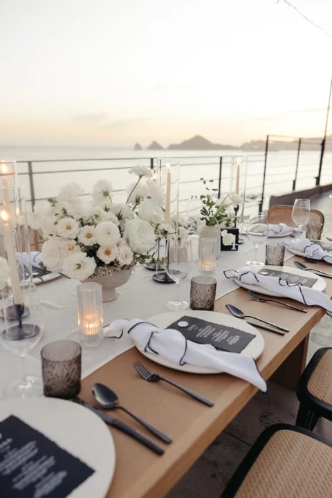 Elegant dining table with floral centerpieces for upscale beach events and receptions.