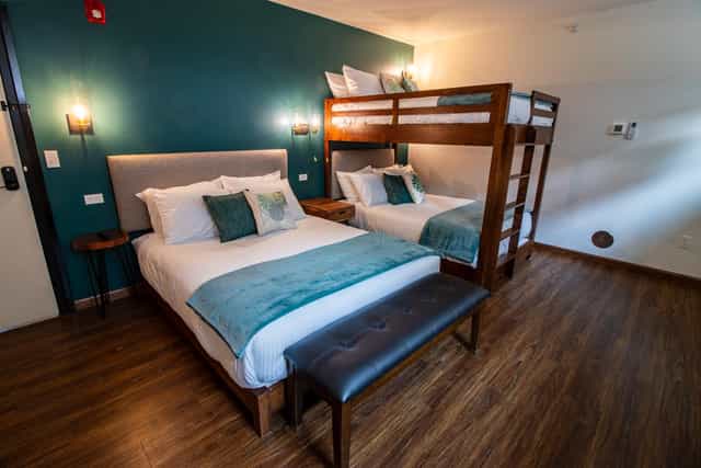 Retreat center hotel room with queen and bunk beds for family events or group stays.