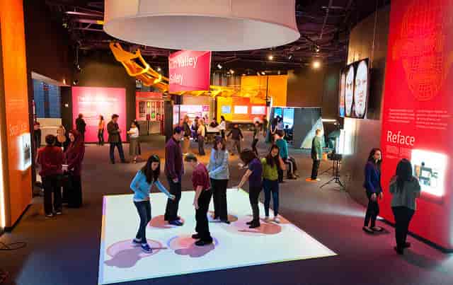 Interactive exhibition space at The Tech Interactive, vibrant colors, networking events.