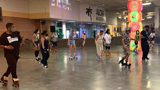 Miniature golf at Aloha Roller Rink during a vibrant community skating event.