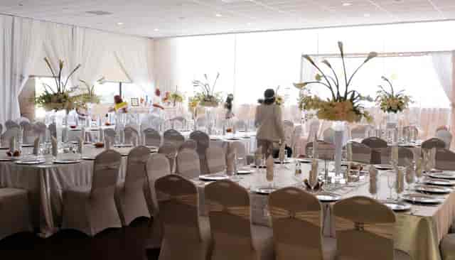 Corporate off-site banquet hall with elegant table settings and floral centerpieces. 