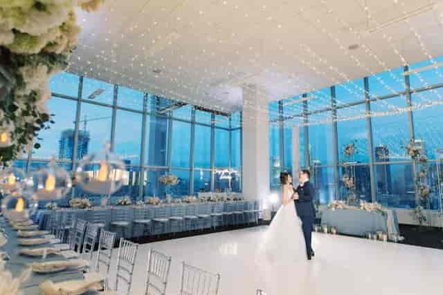 Wedding reception venue with large windows and city views, ideal for romantic events.