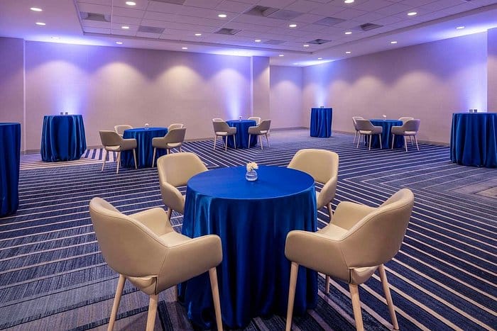 Modern conference center in Hilton San Jose, with blue table linens for networking events.
