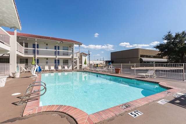Outdoor pool area at Motel 6 Dallas, TX - ideal for events and networking sessions.