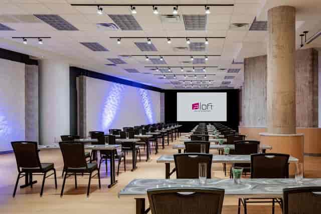 Corporate event space in Aloft Dallas Downtown, featuring modern design and presentation setup.