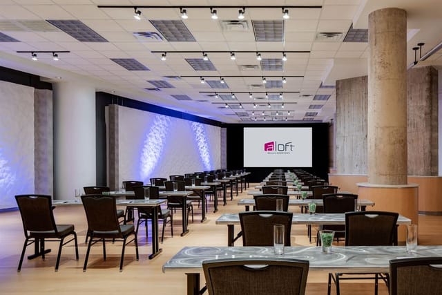 Corporate event space in Aloft Dallas Downtown, featuring modern design and presentation setup.