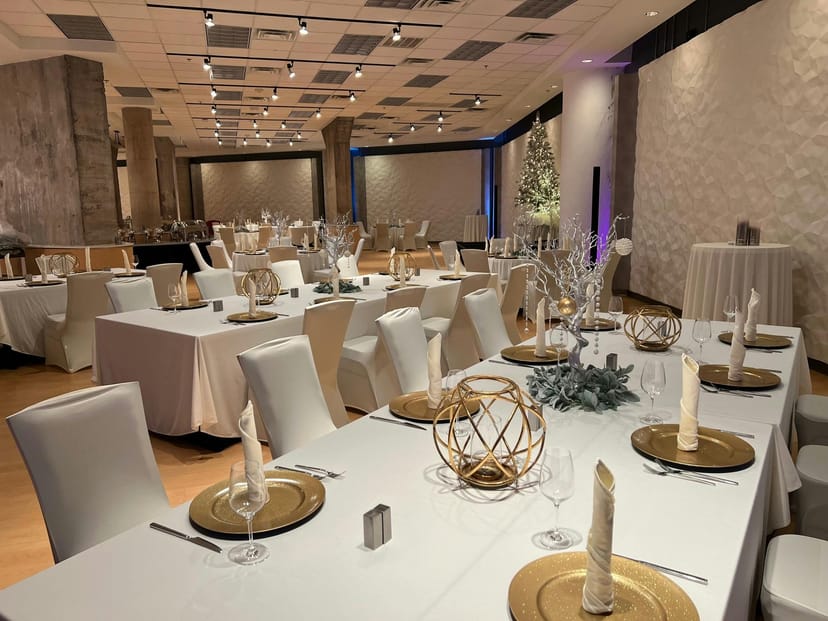 Elegant event space with white table settings and gold accents in Aloft Dallas Downtown.