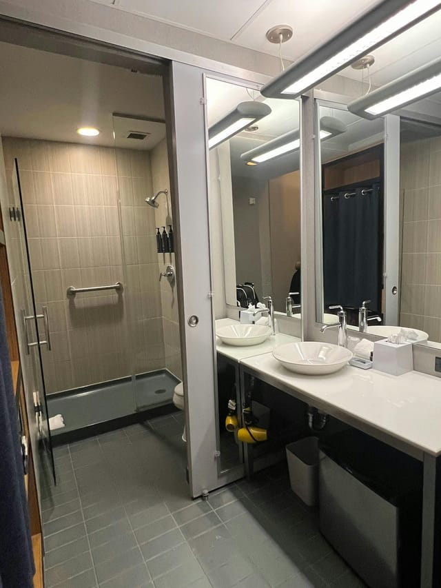 Modern restroom in Aloft Dallas Downtown with dual sinks for events and meetings.