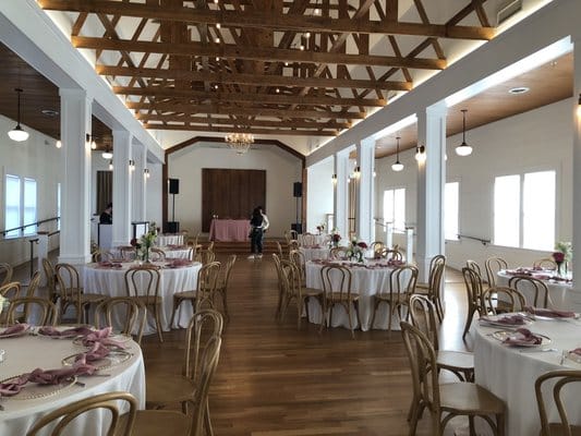 Elegant wedding venue with wooden beams and pink accents in The Cliff House.