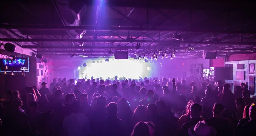 Live music venue in Deep Ellum with vibrant crowd and colorful stage lights.