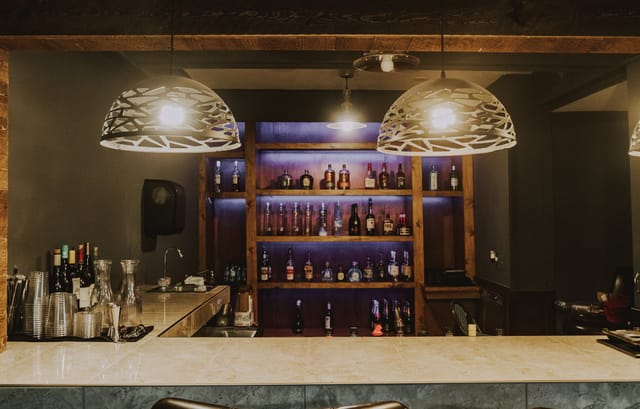 Red Room bar in Five Central Houston, featuring modern lighting for networking events.