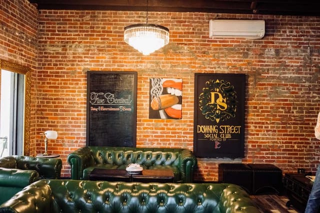 Stylish rustic bar in Houston with exposed brick and green leather seating for events