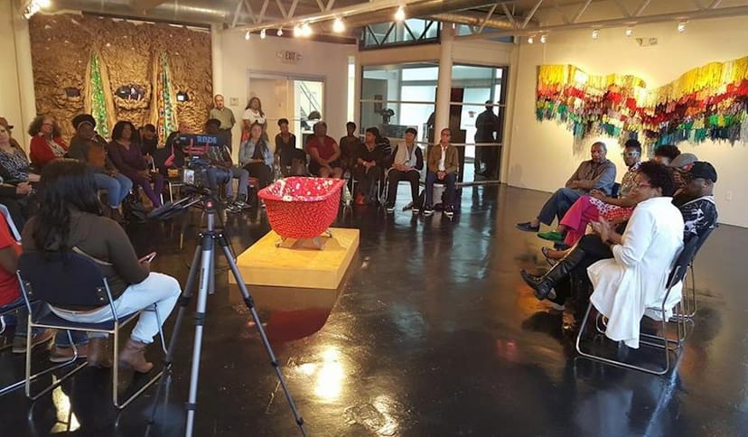Panel discussion at Houston Museum of African American Culture, engaging dialogue in art gallery.