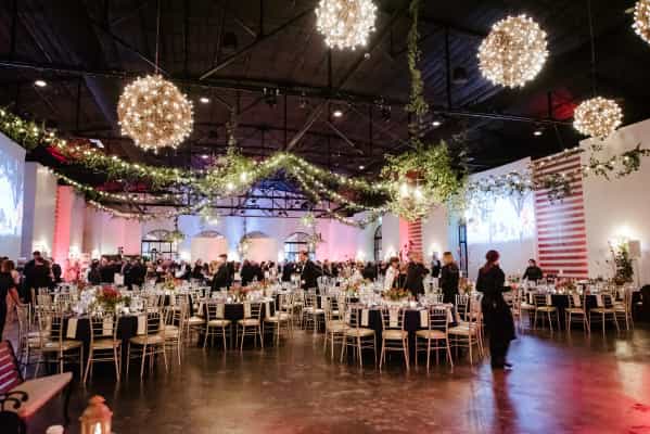 Elegant event space at The Revaire with string lights and lush greenery for gatherings.