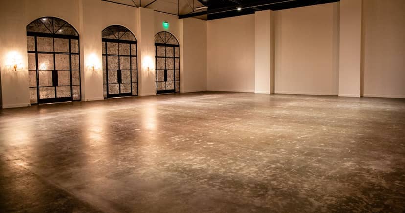Spacious Champagne Suite event space with elegant concrete floor for gatherings.